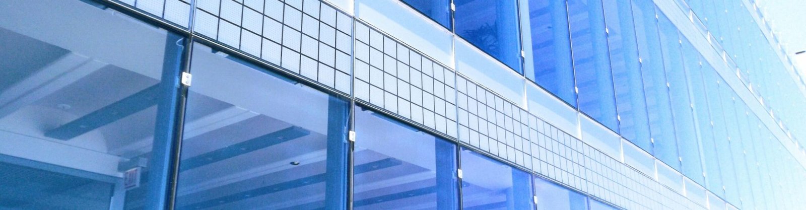 Contemporary glass building facade with reflections in the city, highlighting urban architecture.